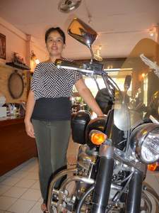 Duan posiert vor der mächtigen Harley in ihrem deutschen Restaurant. Seitdem ihr Mann zurück nach Deutschland gezogen ist, führt sie den Laden alleine.