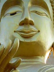 Karma ist alles: Milde lächelnd, in bedächtiger Pose, blickt eine gewaltige Buddha-Statue auf Khong Chiam hinunter.