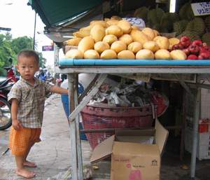 Er kann kaum über den Tisch schauen, aber immerhin ist dieser kleine Marktbesucher groß genug, um sich gleich eine saftige Thai-Mango zu schnappen.