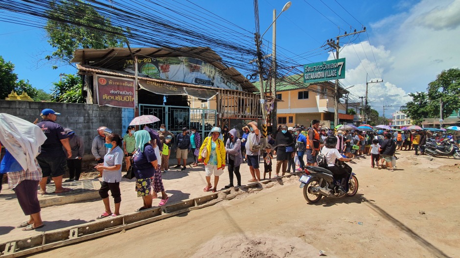 Mehr als 1.000 Menschen standen am letzten Freitag in der Soi Khao Noi Schlange, um Lebensmittel zur Selbstzubereitung in Empfang zu nehmen. Sicherheitskräfte der Stadt Pattaya sorgten für Ordnung. Foto: Jahner
