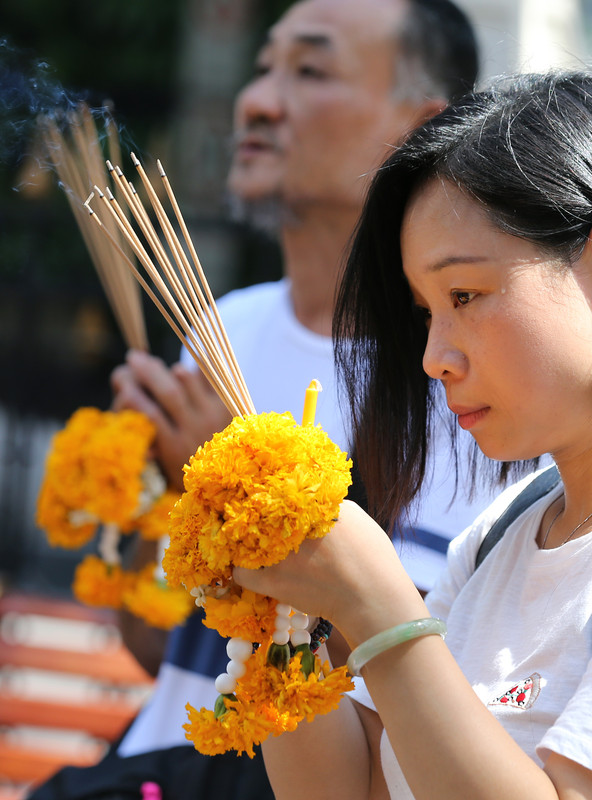 Blumengirlanden werden an Tempeln jeweils mit drei Rauchstäbchen und Lotosknospen oder anderen Blumen verkauft. Foto: epa/Narong Sangnak