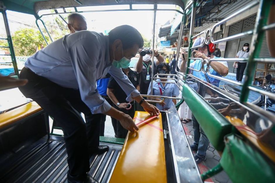 Pattayas Vizebürgermeister-Duo Ronakit Ekasing (v.) und Banlue Kullavanijaya (h.) bekleben die Sitzplätze in einem Songthaew mit Klebestreifen, damit die Fahrgäste Abstand zueinander halten. Foto: PR Pattaya