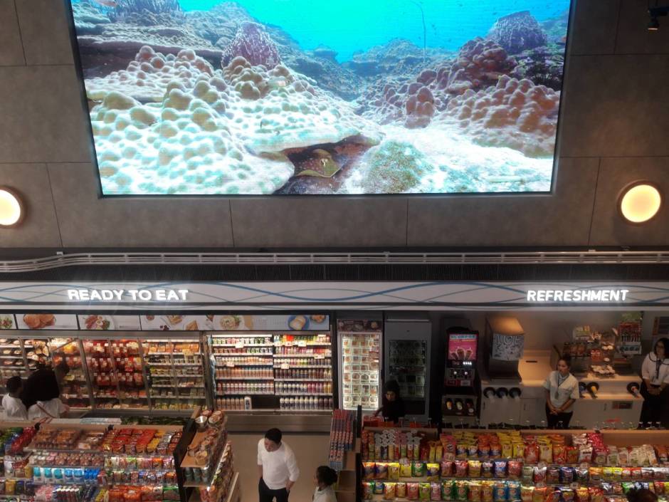 Vom Café in der ersten Etage, das eine kleine Speisekarte enthält und somit auch als Restaurant dient, kann man seine Sinne beim Blick auf das „LED-Aquarium“ entspannen. 