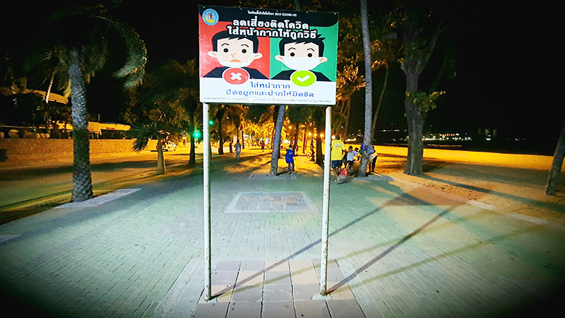 Ein Schild informiert auf der Strandpromenade über die Maskenpflicht.