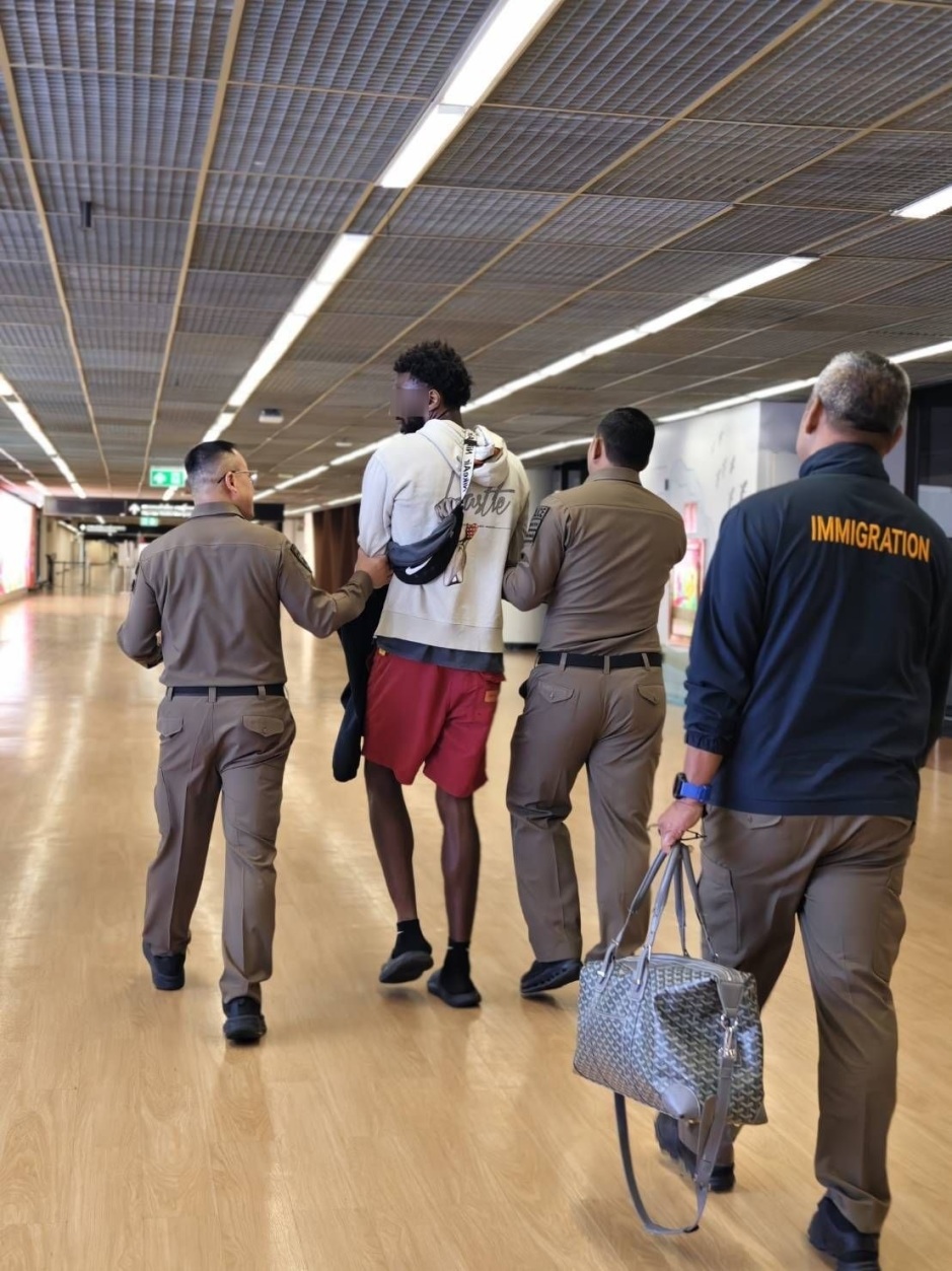 Polizeibeamte begleiten einen Beschuldigten nach seiner Festnahme durch das Flughafenterminal. Bild: TMN.TV