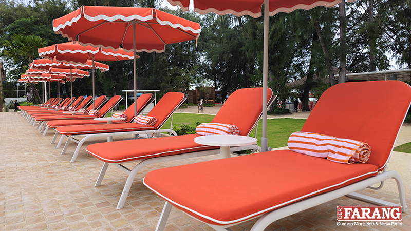 Retro in Orange: Stylische Sonnenliegen und gestreifte Handtücher sorgen für echtes Standard-Flair am Pool.