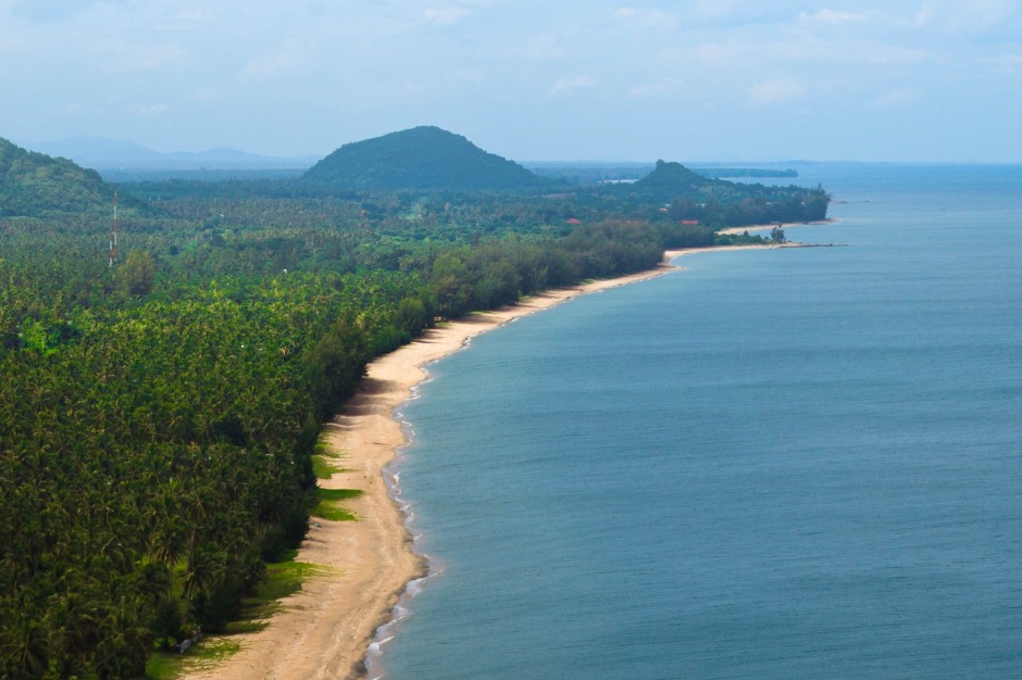 Blick von einer Anhöhe auf die Küste, wo sich Meer und bewaldete Landschaft ohne dichte Bebauung begegnen. Bild: Tourism Authority Of Thailand