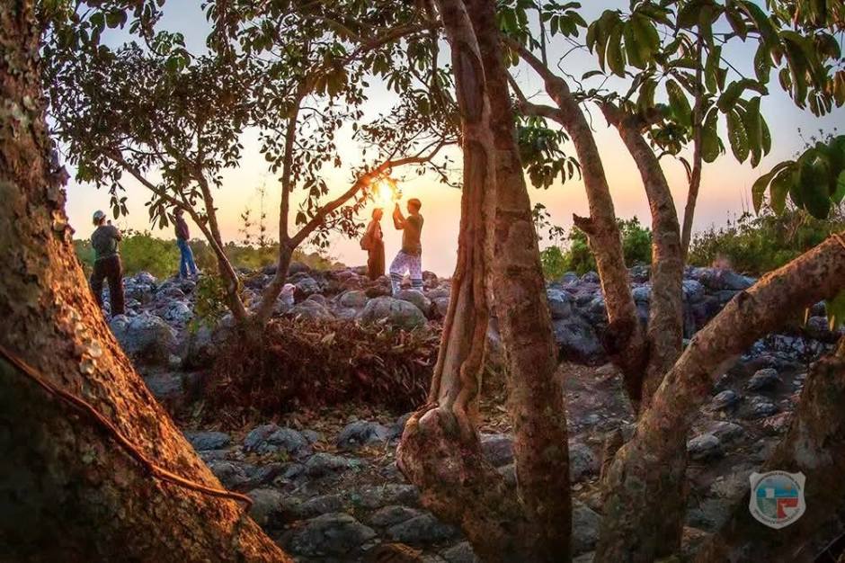 Besucher beobachten den Sonnenuntergang zwischen Felsen und Bäumen in der natürlichen Berglandschaft des Nationalparks. Bild: Department of National Parks, Wildlife and Plant Conservation (DNP)