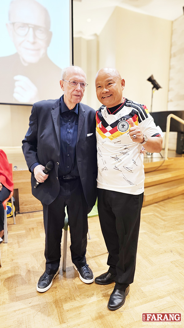Calli überreicht Khun Nigon ein signiertes DFB-Trikot.
