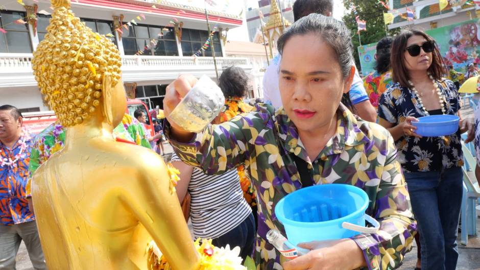 Eine Besucherin gießt Wasser über eine Buddha-Statue – Teil der traditionellen Waschung zur Bitte um Glück und Segen. Bild: TMN.TV