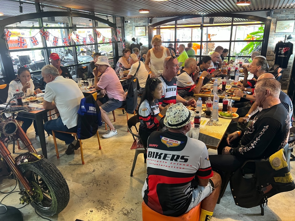 Gut besuchter Gastraum während eines Events im The Bikers Café Thailand mit Gästen beim Buffet und gemeinschaftlichem Austausch.