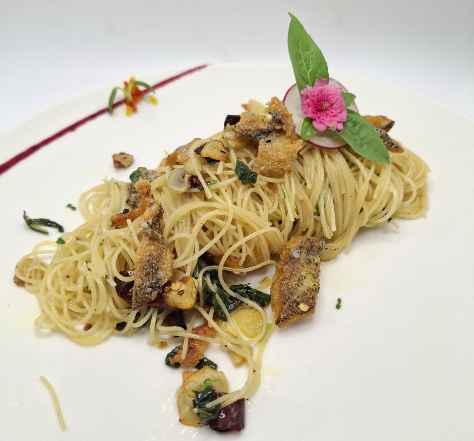 Die würzigen Capellini werden mit knusprig gebratenem Gourami-Fisch serviert.