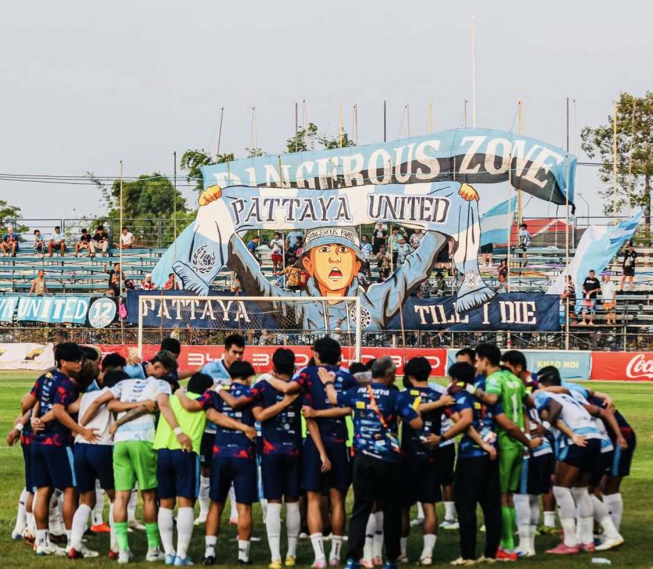 Einschwören auf den Klassenerhalt: Pattaya United vor dem letzten Heimspiel. Im Hintergrund die Choreo der „Pattaya United Dangerous Family“. Foto: Pattaya United