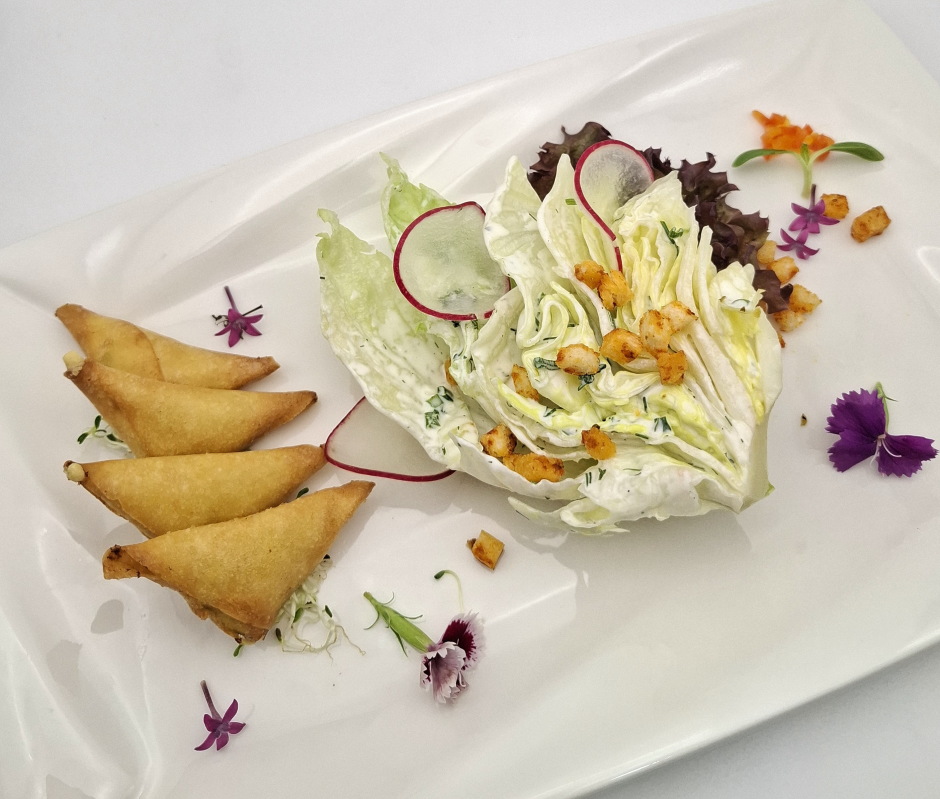 Frittierte Jalapeño-Cream-Cheese-Samosas mit Iceberg-Wedge-Salat, Ranch-Dressing und knusprigen Croutons.