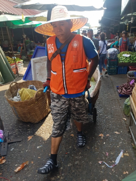 Träger mit Karren drängen sich durch den Markt.