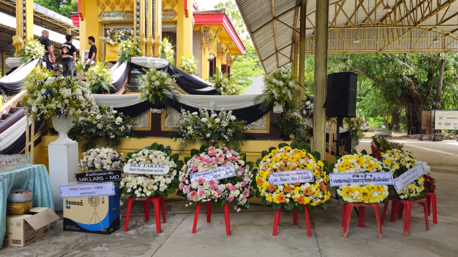 Blumenkränze von Freunden, Nachtlebenbetrieben und Medien schmücken den Aufgang zum Krematorium im Wat Nalikawanaram. Bild: Jahner