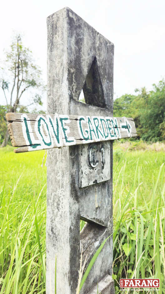 Ein Wegweiser am Straßenrand führt zu Somchais's Love Garden.