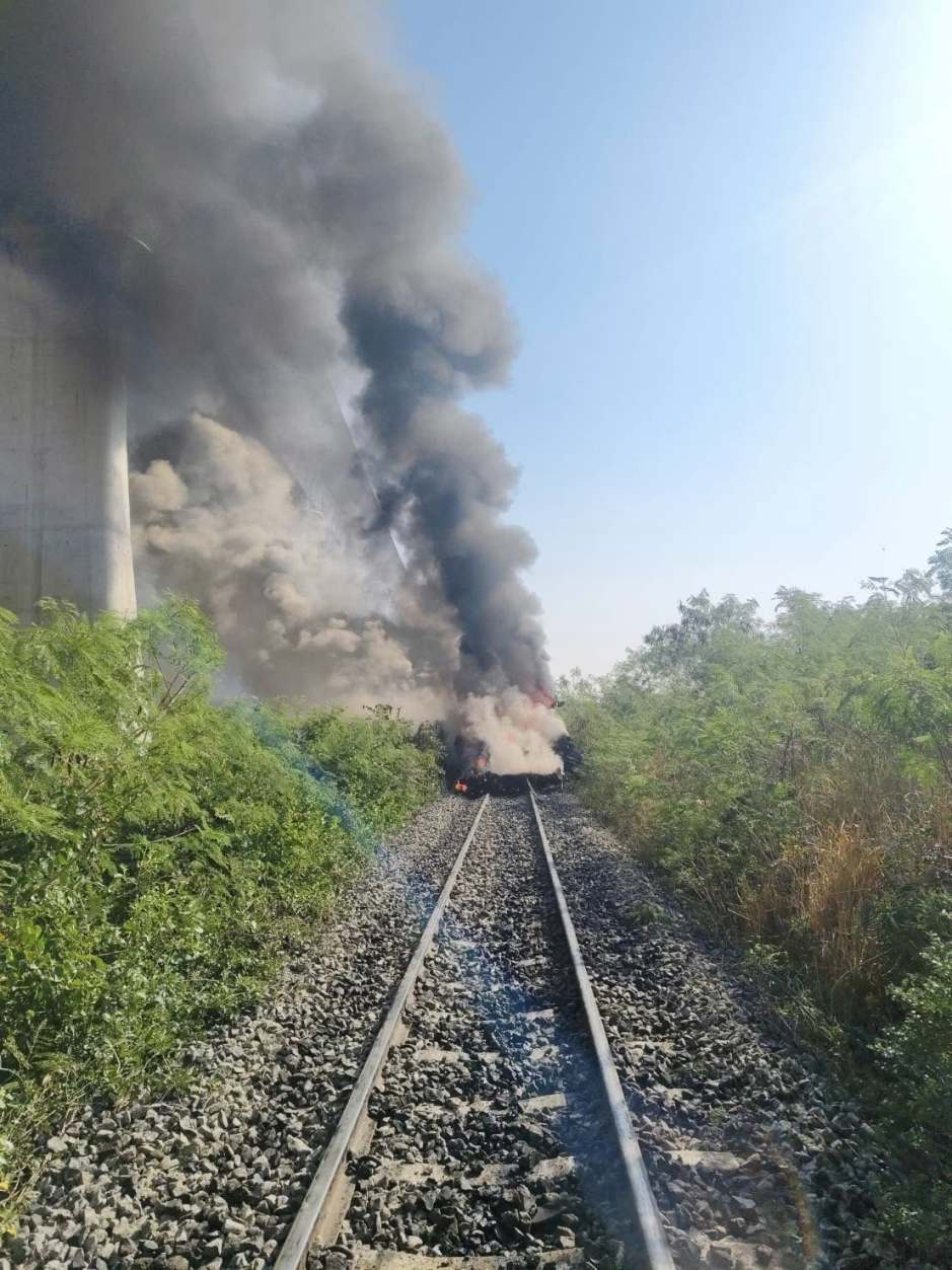 Rauch steigt aus den Trümmern an der Unfallstelle auf, während Einsatzkräfte den betroffenen Streckenabschnitt sichern. Foto: Fire & Rescue Thailand