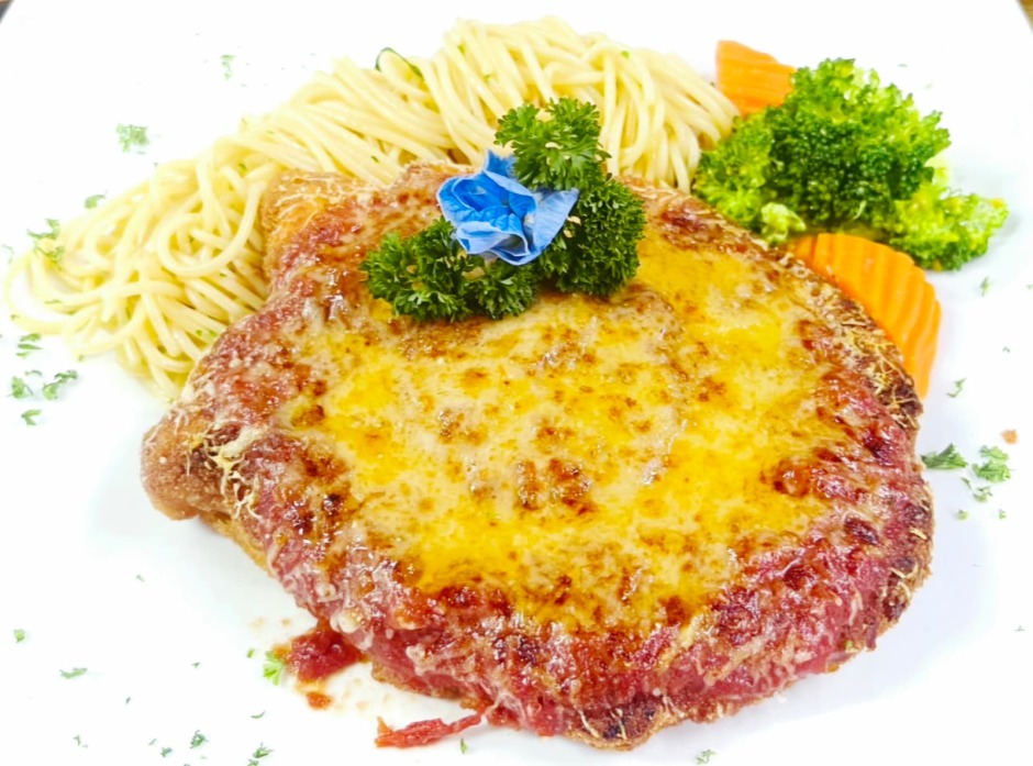 Überbackene Hähnchenbrust mit Parmesan und Tomatensauce, begleitet von Butter-Spaghetti.