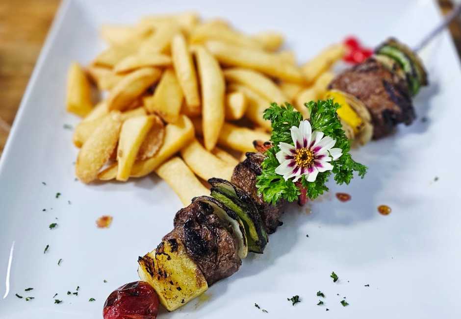 Gegrillte Rindfleischstücke mit Peperoni, Zwiebeln, Ananas und Kirschtomaten sorgen für herzhaften Genuss.