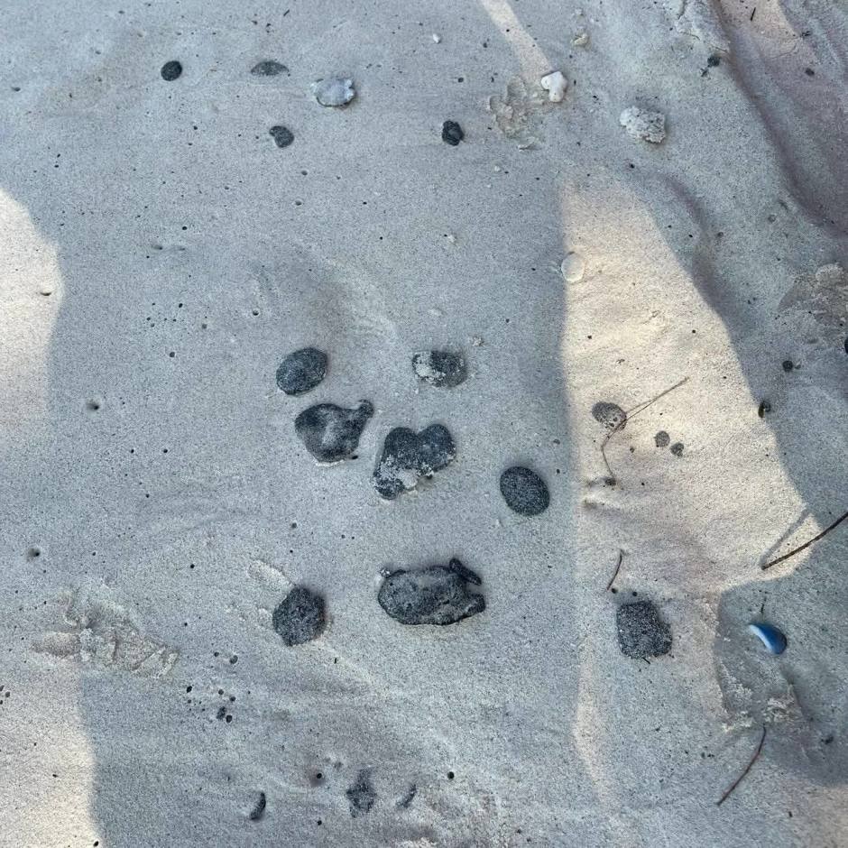Verfestigte Teerklumpen liegen verstreut im hellen Sand entlang des Strandabschnitts. Foto: Newshawk Phuket