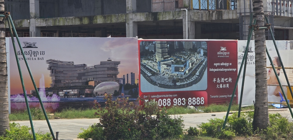 Das Plakat zeigt die Vision von Peninsula Bay: ein modernes Resort mit ikonischem Design, Einkaufszentren und Gastronomie in Sihanoukville. 