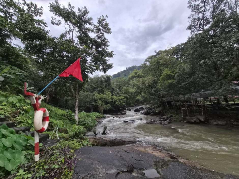 Rote Warnflagge und Rettungsring weisen auf erhöhte Vorsicht hin – Ranger überwachen ständig den Wasserstand.