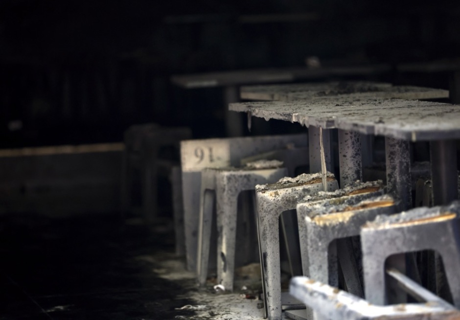 Die Ermittler untersuchen den ausgebrannten Gastraum, in dem sich das Feuer innerhalb weniger Minuten ausgebreitet haben soll. Foto: epa/Rungroj Yongrit