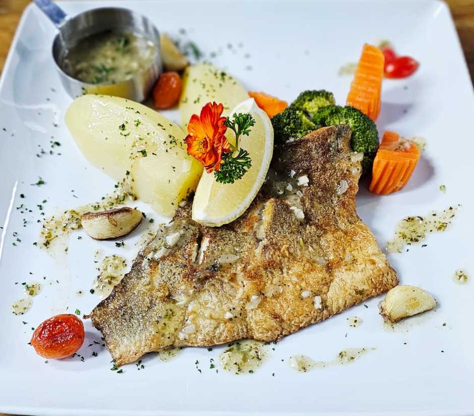 Gebratenes Red-Tilapia-Filet mit Zitronen-Buttersauce, Salzkartoffeln und Buttergemüse. Bild: Jaybee'Swiss Restaurant