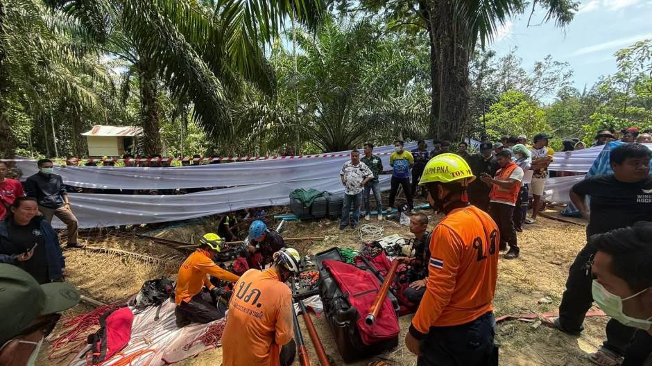 Zahlreiche Helfer sichern die Einsatzstelle ab, während Ausrüstung für die aufwendige Bergung vorbereitet wird. Bild: Newshawk Phuket