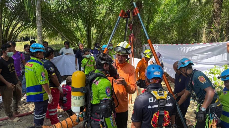 Einsatzkräfte mit Atemschutz und Spezialgerät koordinieren die Bergung der Opfer aus dem engen Brunnenschacht. Bild: Newshawk Phuket