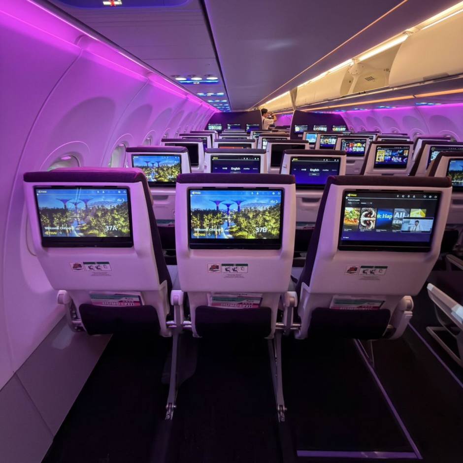 Blick in die Economy Class mit individuellen Bildschirmen und LED-Ambientebeleuchtung.