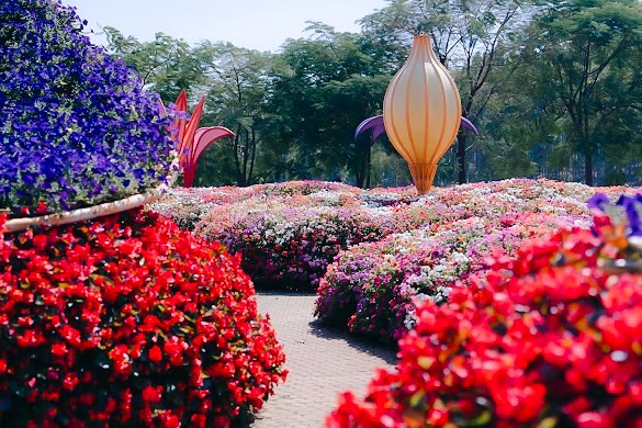 Thematisch gestaltete Blumenbeete mit Skulpturen als Teil der saisonalen Parklandschaft.