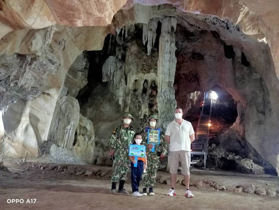 Ranger des Wildschutzgebiets und Besucher posieren vor markanten Stalaktiten und Stalagmiten im Höhleninneren. Bild: Department of National Parks, Wildlife and Plant Conservation (DNP)