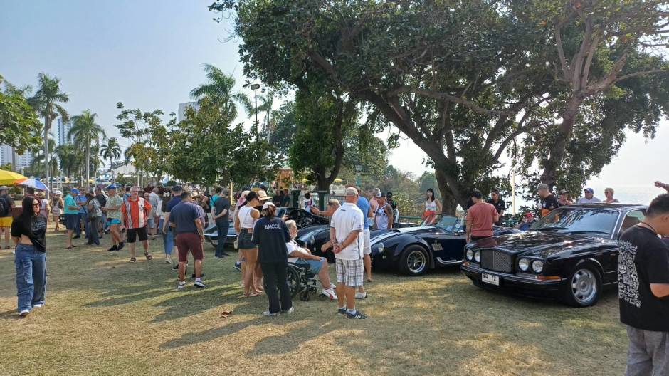 Besucher begutachten historische Fahrzeuge im Parkbereich des Hotels.