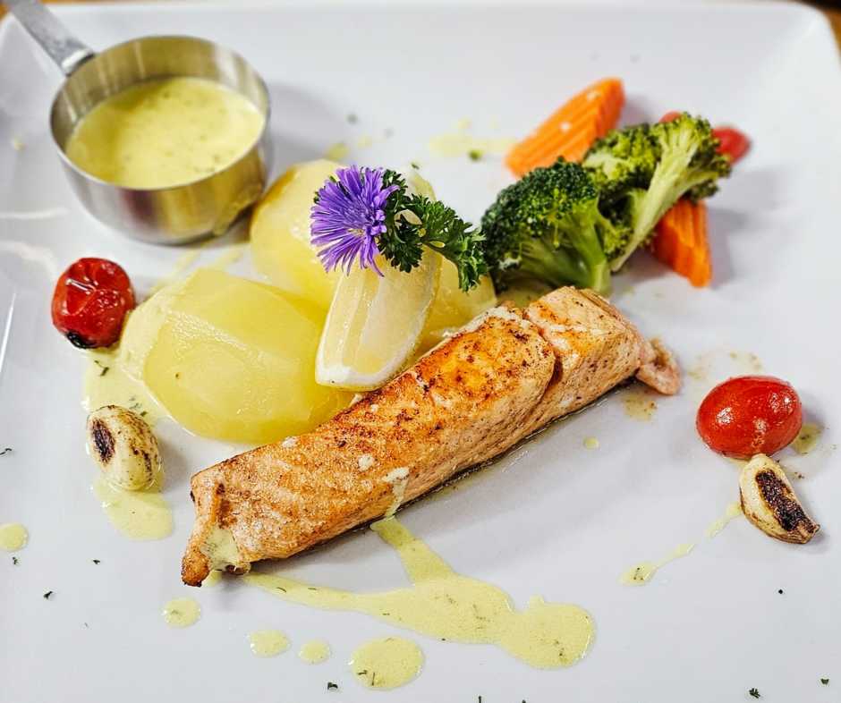 Gebratenes Forellenfilet mit Dill-Senfrahmsauce, dazu Salzkartoffeln und Gemüse.