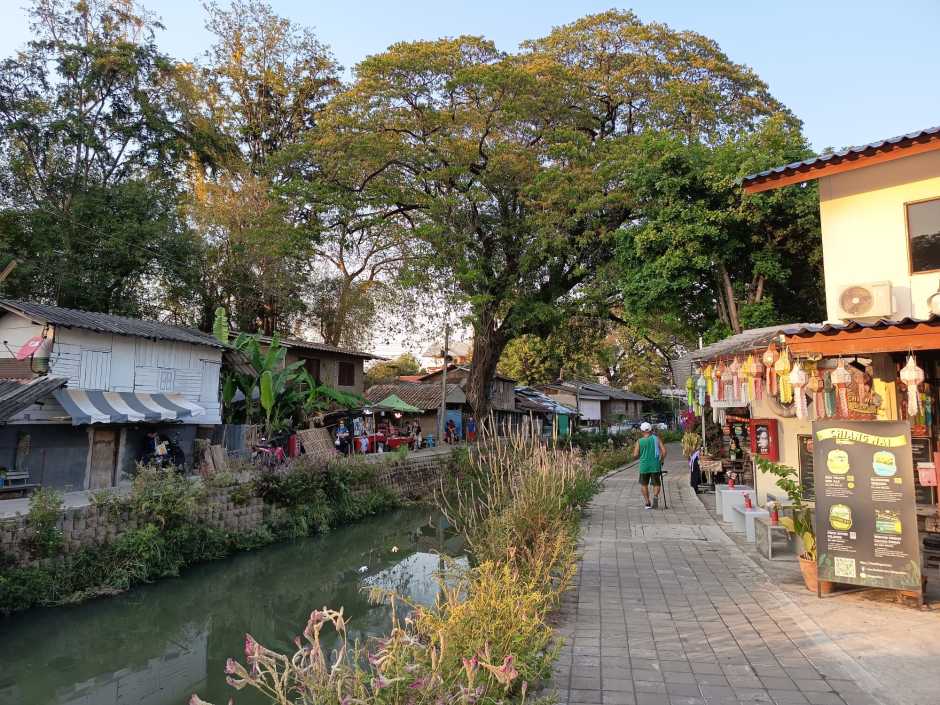 Spazierweg, Bäume und kleine Läden säumen den Mae-Kha-Kanal in Chiang Mai am späten Nachmittag. Foto: DER FARANG