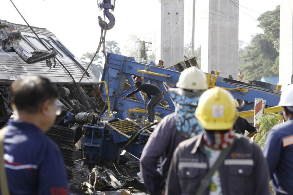Arbeiter begutachten die Trümmer eines Passagierzugs, nachdem im Bezirk Sikhio ein Baukran auf den Zug gestürzt war. Foto: epa/Narong Sangnak
