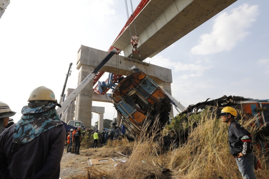 Bergungsarbeiten nach dem schweren Zugunglück in der Provinz Nakhon Ratchasima: Einsatzkräfte sichern einen entgleisten Waggon, nachdem ein Baukran auf den Zug gestürzt war. Foto: epa/Narong Sangnak