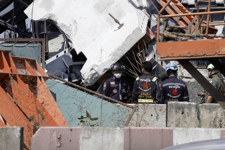 Einsatzkräfte untersuchen die Trümmer an der Unglücksstelle in Samut Sakhon, wo ein Baukran auf eine Schnellstraße gestürzt ist und Fahrzeuge unter sich begrub. Foto: epa/Narong Sangnak
